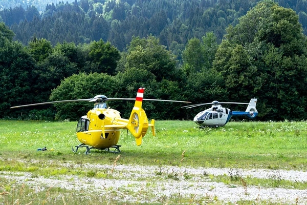Ambulance and police helicopters landed in a mountainous village in the field. — Stock Photo, Image