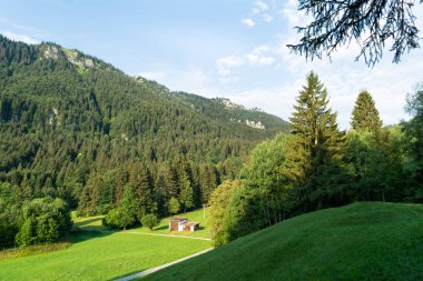 Su kuyusu-damat alpine meadows outbuildings ve mesafe içine uzanan yol görünümünü.