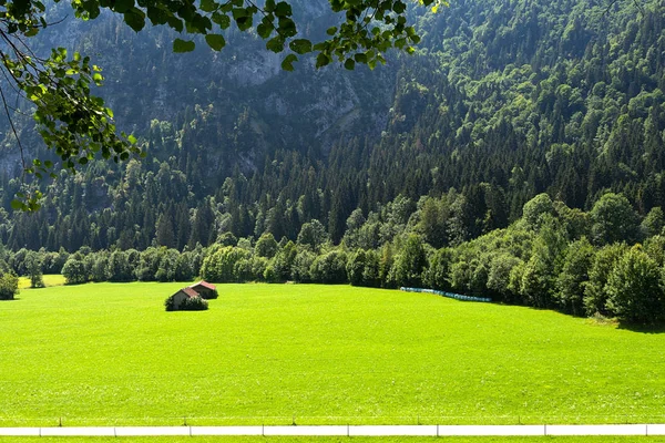 Vista de los prados alpinos bien cuidados con dependencias sobre el telón de fondo de las montañas . — Foto de Stock