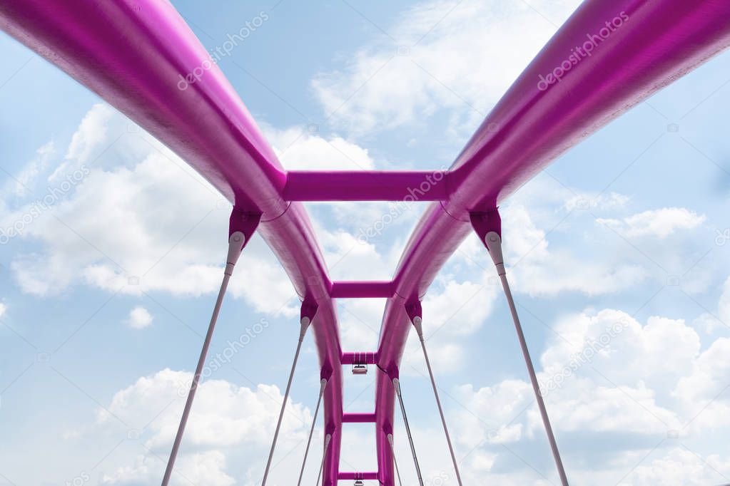 View of the upper structure of the fuchsia bridge against the blue sky