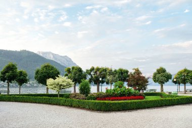 Dağlar, göl ve dolgu ile kesilmiş ağaçlar, çalılar ve çiçek yatak şehrin görünümünü.