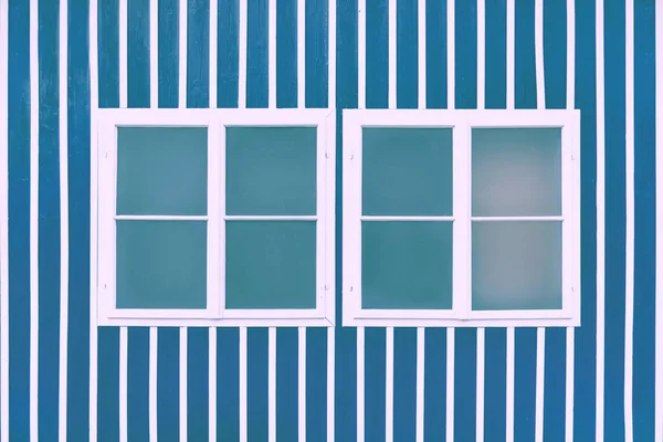 Два двойных белых окна на голубой стене с белыми решетками . — стоковое фото