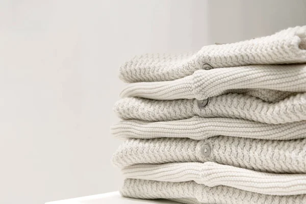 Suéteres beige hechos de telas naturales se pliegan en la mesa . — Foto de Stock