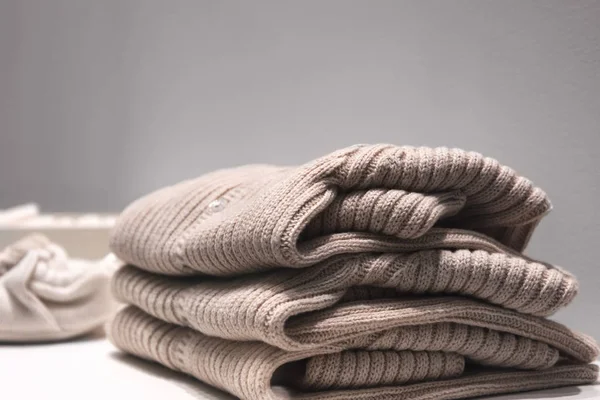 Beige truien gemaakt van natuurlijke stoffen zijn gevouwen op de tafel. — Stockfoto