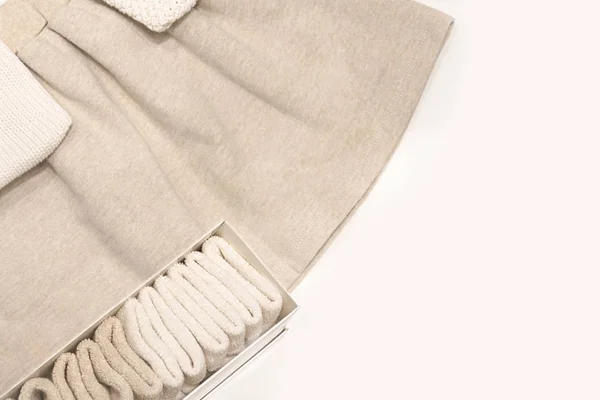 Vista dall'alto su una gonna beige, maglioni e calzini realizzati con tessuti naturali che giacciono sul tavolo . — Foto Stock