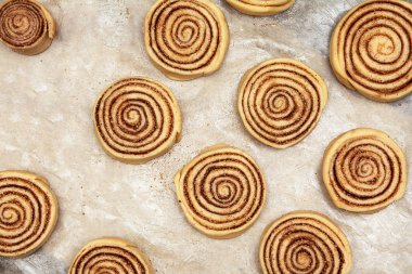 Tarçın rulo hamur boşluklar yağlanmış parşömen kağıt üzerinde