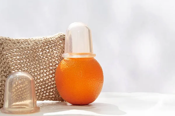 Ένα πορτοκαλί με ένα κενό μπορεί να στην κορυφή είναι στο τραπέζι με φόντο ένα πλέγμα πετσέτα φτιαγμένο από φυσικές ίνες — Φωτογραφία Αρχείου