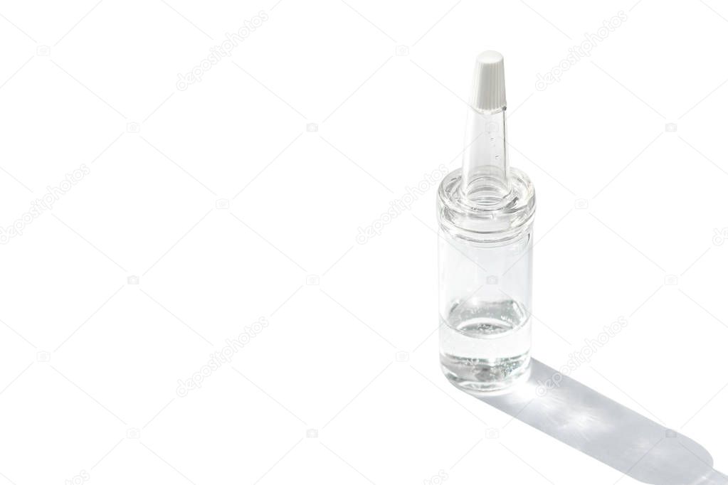 Glass bottle with a pipette and transparent serum on a white background