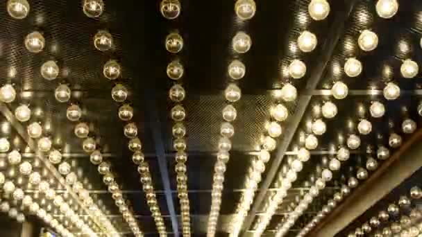 大圆形灯泡以光栅和闪烁的白光的形式在黑色金属天花板上成排长队连接 — 图库视频影像