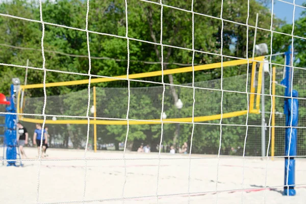View of the beach volleyball court through the safety net