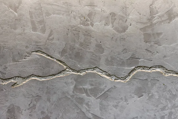 A textura da parede de concreto cinza é decorada com uma profunda rachadura de cor prata . — Fotografia de Stock
