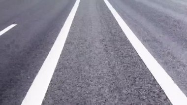 Motorcuyla bir adamın elektrikli scooter sürdüğü bölme şeridinde arabasız yol..