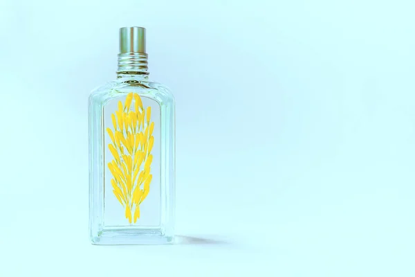 Átlátszó Parfümös Üveg Kék Háttérrel Sárga Virágszirmokkal Díszítve — Stock Fotó