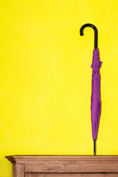 Składany Parasol Purpurowy Kolor Stoi Drewnianej Klatce Piersiowej Tle Żółtego — Zdjęcie stockowe
