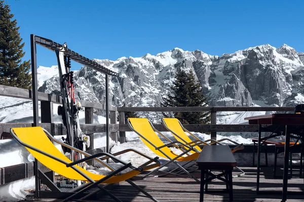 View of the cafe outdoor terrace on the ski slope with orange loungers on it. — Stock Photo, Image