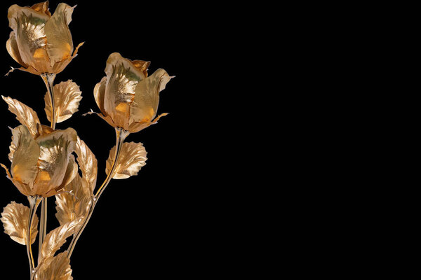 Contemporary collage. Gold colored metal roses on a black background.