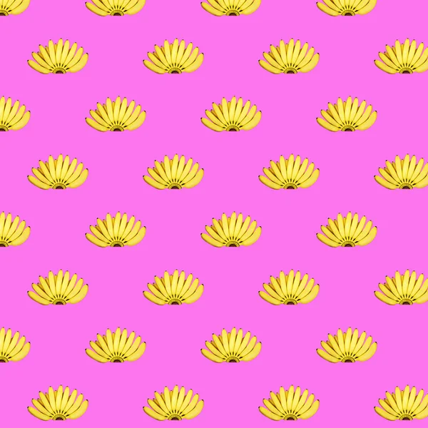 Płynny wzór kilku żółtych bananów na różowym tle. Koncepcja jedzenia, lato. — Zdjęcie stockowe