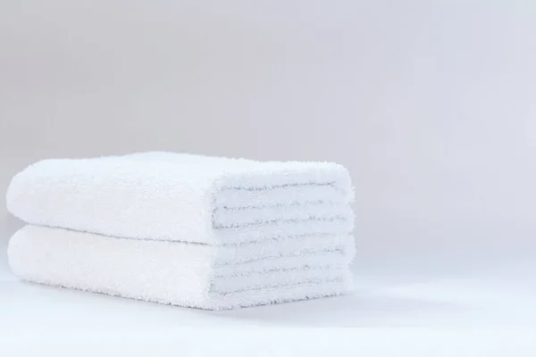 浅色背景上的两条白色整齐折叠的毛巾布 — 图库照片