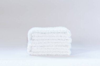 Aydınlık bir arkaplanda iki beyaz terry havlu.