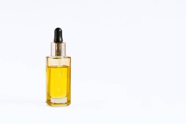 Beyaz arka planda fındık yağlı pipetli cam şişe.