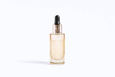 Bir şişe altın rengi, gözlerinde de cilt bakımı için serumla birlikte pipet..