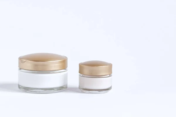 Een set voor huidverzorging rond de ogen en huid bestaande uit glazen potten met crème en serum. — Stockfoto
