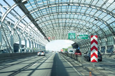 Polonya. Varşova. 06.07.2019 Otobanın ses geçirmez metal yapının altında kemer biçiminde araba süren görüntüsü