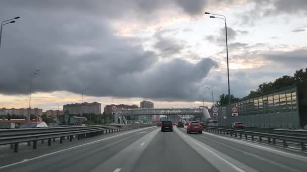 Rosja. Moskwa. 18.09.2020 Widok przez przednią szybę samochodu na sześciopasmowej autostradzie z wymiennikami i napowietrznych przejść dla pieszych w mieście, po których poruszają się samochody. — Wideo stockowe