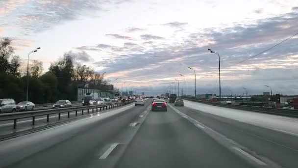 A Rússia. Moscovo. 18.09.2020 Ver através do pára-brisas de um carro em uma estrada de oito faixas com intercâmbios na cidade ao longo da qual os carros dirigem e um engarrafamento se formou na próxima faixa. — Vídeo de Stock