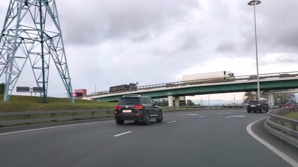 A Rússia. Moscovo. 18.09.2020 Vista através do pára-brisas de um carro. O carro sobe ao longo do intercâmbio na Moscow Ring Road contra o pano de fundo de edifícios residenciais modernos e um céu sombrio. — Vídeo de Stock