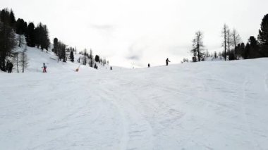 Kayak merkezi Folgarida Marilleva.Folgarida Marilleva.Italya.16.02.2020 Kayak pisti insanların bulutlu bir havada kasvetli bir gökyüzünün arka planına doğru sürdükleri en üst manzara. İnsanlar, spor