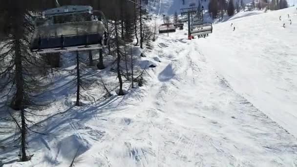 Ovanifrån från en rullstolslyft till skidbacken med hopp. Människor, sport, landskap koncept. — Stockvideo