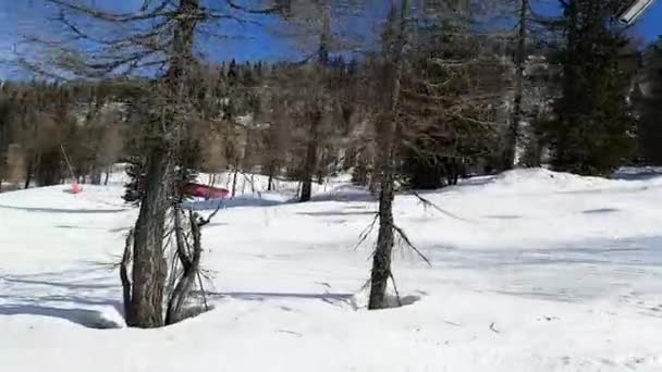 Zicht op een meisje dat langzaam over een skipiste rijdt met sprongen. Mensen, sport, landschap concept. — Stockvideo