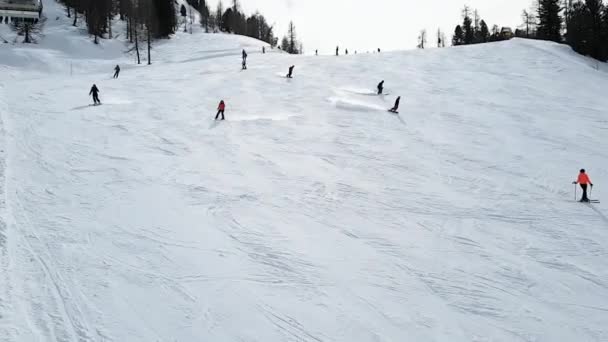 滑雪胜地Folgarida Marillev.Folgarida Marillev.Italy.2020年2月16日在阴天的背景下，人们开车疾驰而过的滑雪坡的最高视图。People, sports, landscape — 图库视频影像