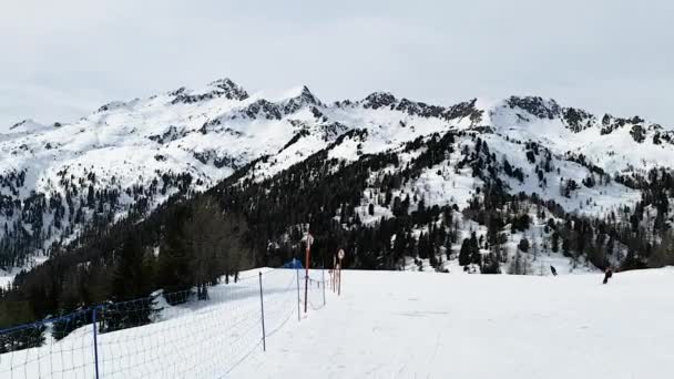 En vy över de snötäckta topparna av Dolomiterna i Italien från skidbacken längs vilken människor rider. Begreppet sport, landskap, människor. — Stockvideo