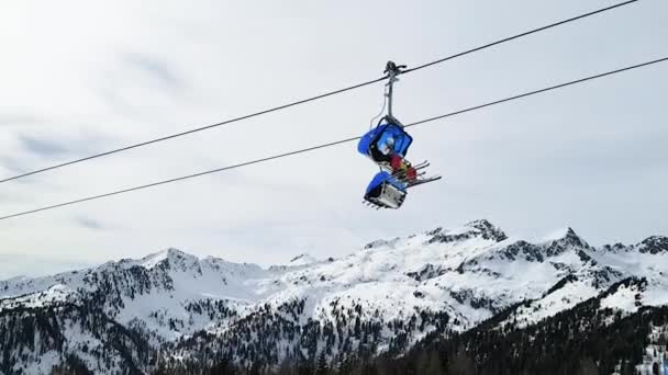 滑雪胜地Folgarida Marillev.Folgarida Marillev.Italy.2020年2月16日在意大利白云石白雪覆盖的山峰的背景下，坐在椅子电梯里的人们的景象 — 图库视频影像