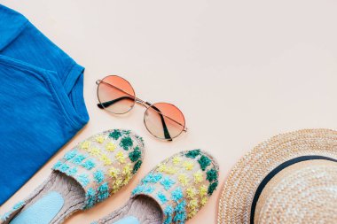 Yaz moda flatlay ile espadrille sandalet, t-shirt, degrade yuvarlak güneş gözlüğü ve bej renkli arka plan üzerinde hasır şapka. Mükemmel kumsal için denizde tatil ayarla. Marina stili.