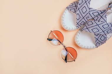 Degrade yuvarlak güneş gözlüğü ve bej renkli arka plan üzerinde espadrille sandal ile yaz moda flatlay. Mükemmel kumsal için denizde tatil ayarla. Marina stili.