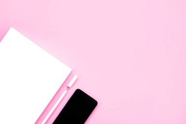Güzel Ofis Kırtasiye flatlay çizgili defter, beyaz kalem ve pembe bir arka plan ile parlak masaya smartphone ile.