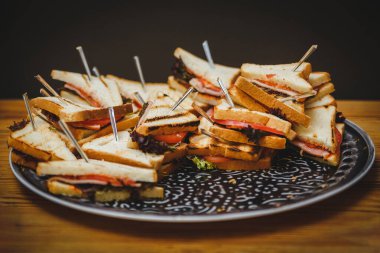 Jambon ve peynirli, taze pişmiş üçgenli büyük tabak. Lokanta, stand-up yemeği ya da ziyafet için fotoğraf. Partideki lezzetli yemekler.