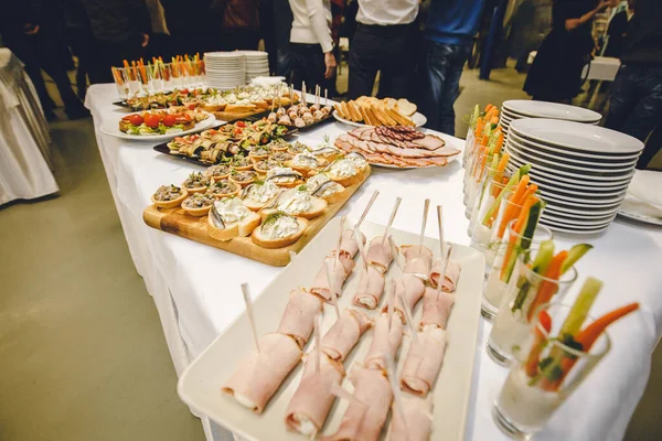 Öğle yemeği molası. Sebzelerle stand-up yemeği. Uzun cam jambon ve peynirli mantar sepetleri. Balık ve soslu tost. Sosisli ekmek. Tabaklar ziyafet için hazır. Restoran fotoğrafı.