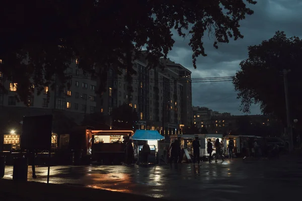 Gıda şirketi alacakaranlıkta ya da gecede kamp yapıyor. İnsanlar yemek servisi yapan kafeden gece kentinde dolaşıyorlar. Yaz geceleri sakin bir atmosfer. İşten sonra ortam rahatlatıcı.