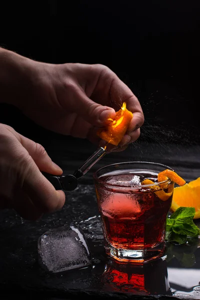 Cocktail Mezcal Negroni. Aperitivo italiano fumegante. Casca de laranja flamejada . — Fotografia de Stock