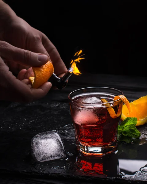 Mezcal Negroni cocktail. Rökig italiensk aperitivo. Flammade apelsinskal. — Stockfoto