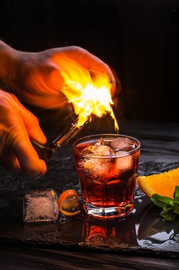 Mezcal Negroni cocktail. Smoky Italian aperitivo. Flamed orange peel. clipart