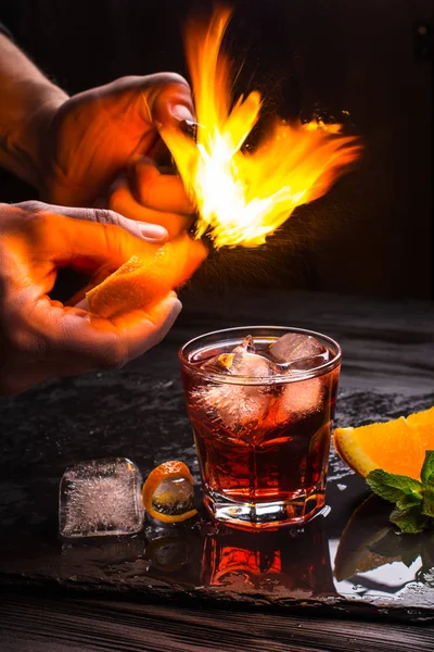 メスカル ネグローニ カクテル。煙のようなイタリアのアペリティーボ。オレンジの皮を燃え上がる. — ストック写真