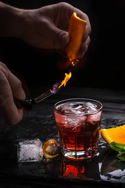 Cóctel Mezcal Negroni. Aperitivo italiano ahumado. Piel de naranja flameada . — Foto de Stock