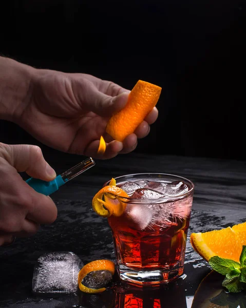 Mezcal Negroni Cocktail Med Eld Apelsinskal Och Händer Italiensk Aperitivo — Stockfoto