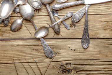 Ahşap bir masa üzerinde eski süslü çatal bıçak takımı