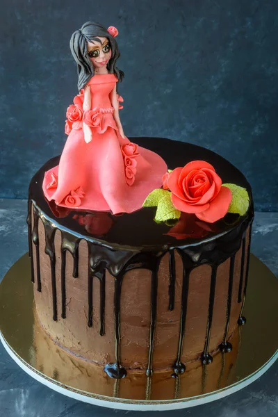手作りのケーキに赤いドレスを着た女の子の姿で黒いチョコレート艶出しが覆われている 暗い背景に赤い薔薇 — ストック写真